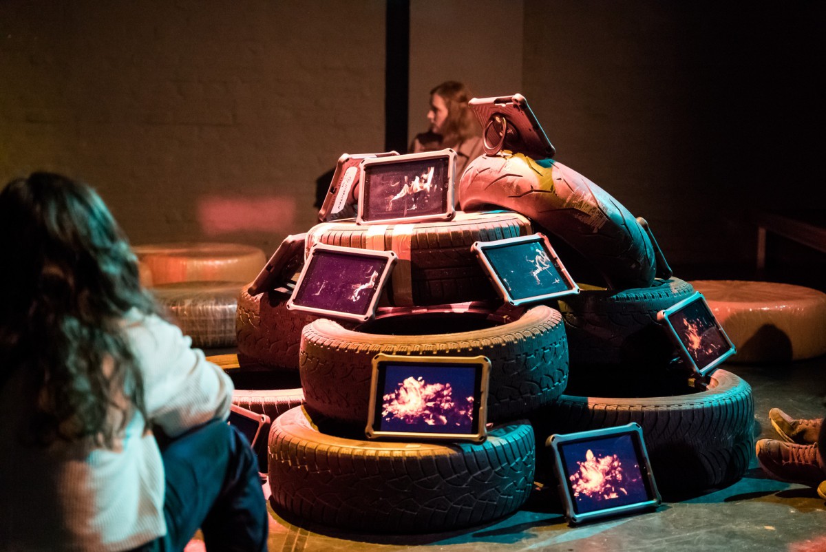 A tower. made of car tires on which asome tablets are placed