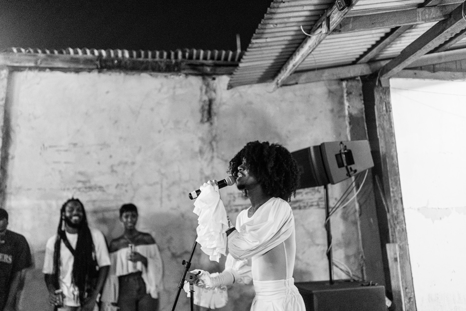 Ein schwarzweiß Foto von Sibb, der in ein Mikrofon singt