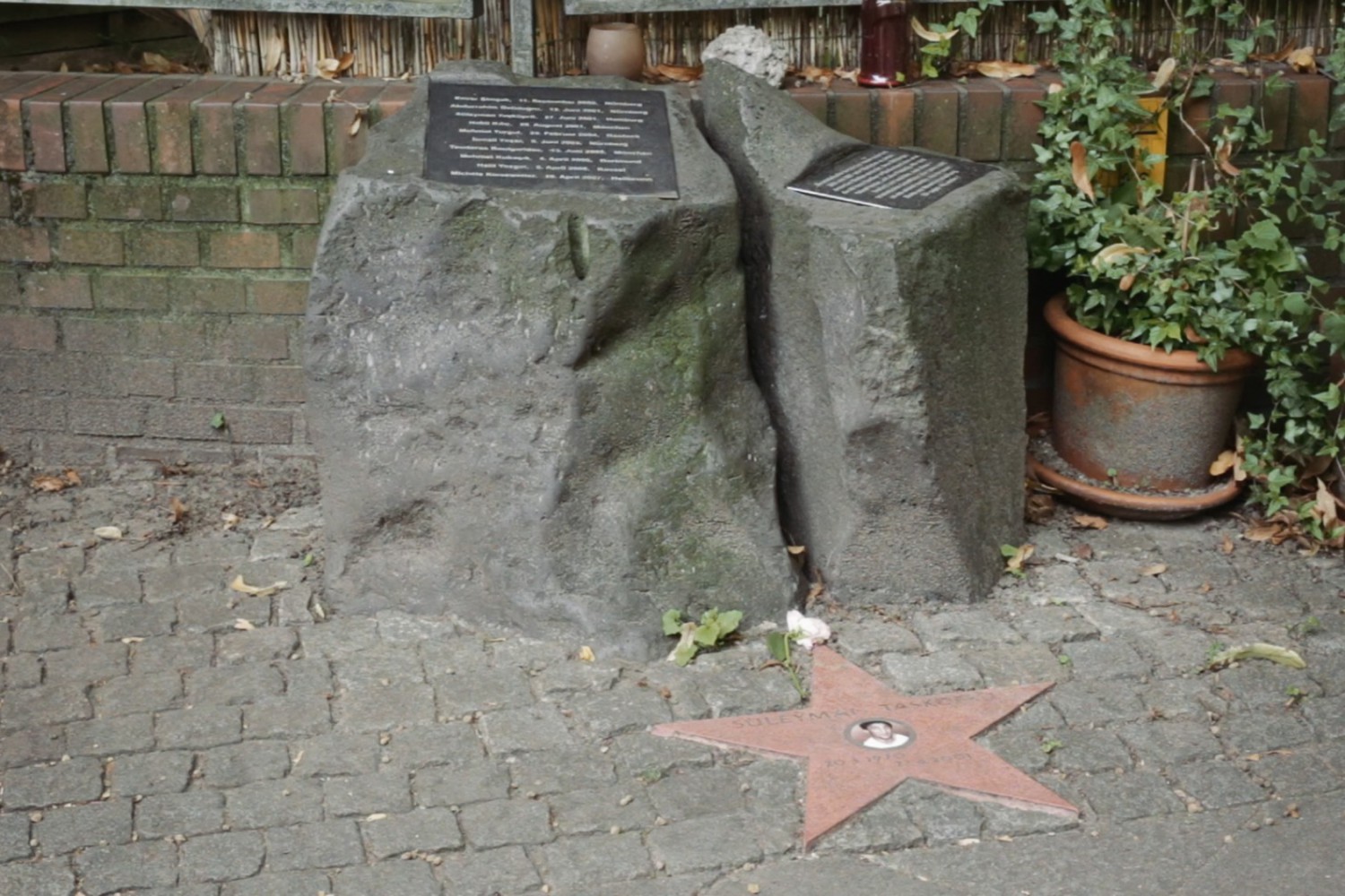 Szene aus dem Film "Der zweite Anschlag", in der man ein Denkmal für eine ermordete Person sieht.