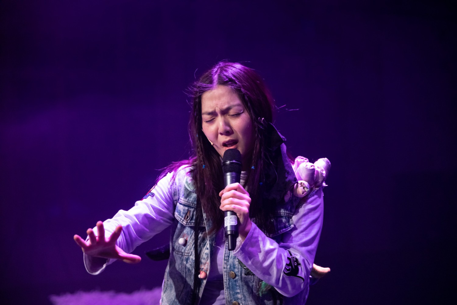 Hyunsin Kim sings with a pained expression on her face.