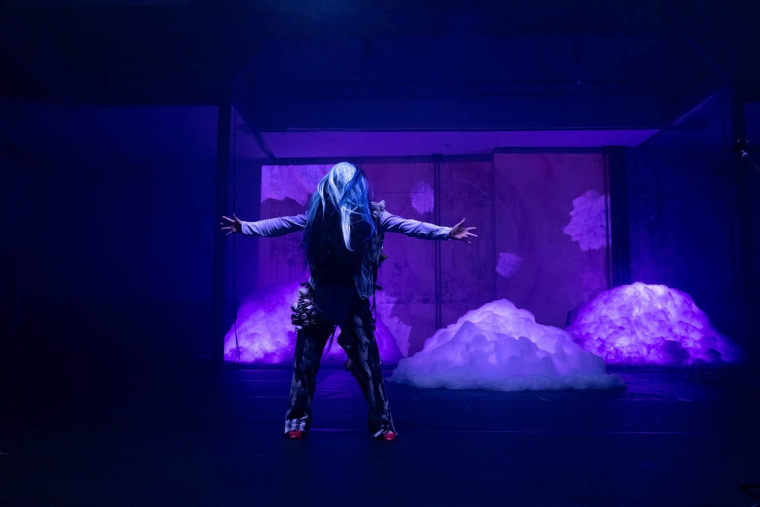 A person in a monster-like fur costume with outstretched arms