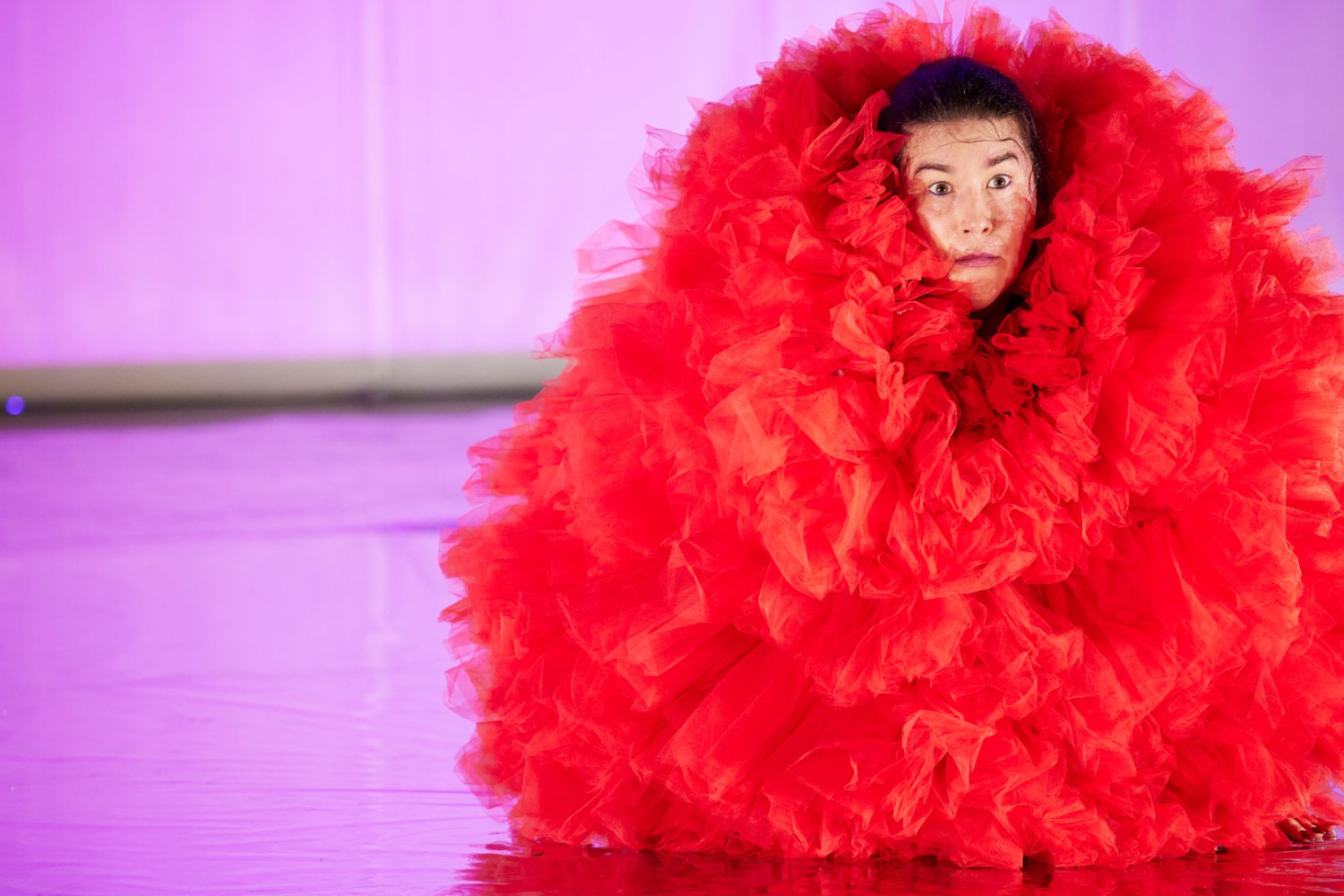Daniela Ruocco in einem roten Pompom-Kostüm, aus dem nur ihr Gesicht rausguckt