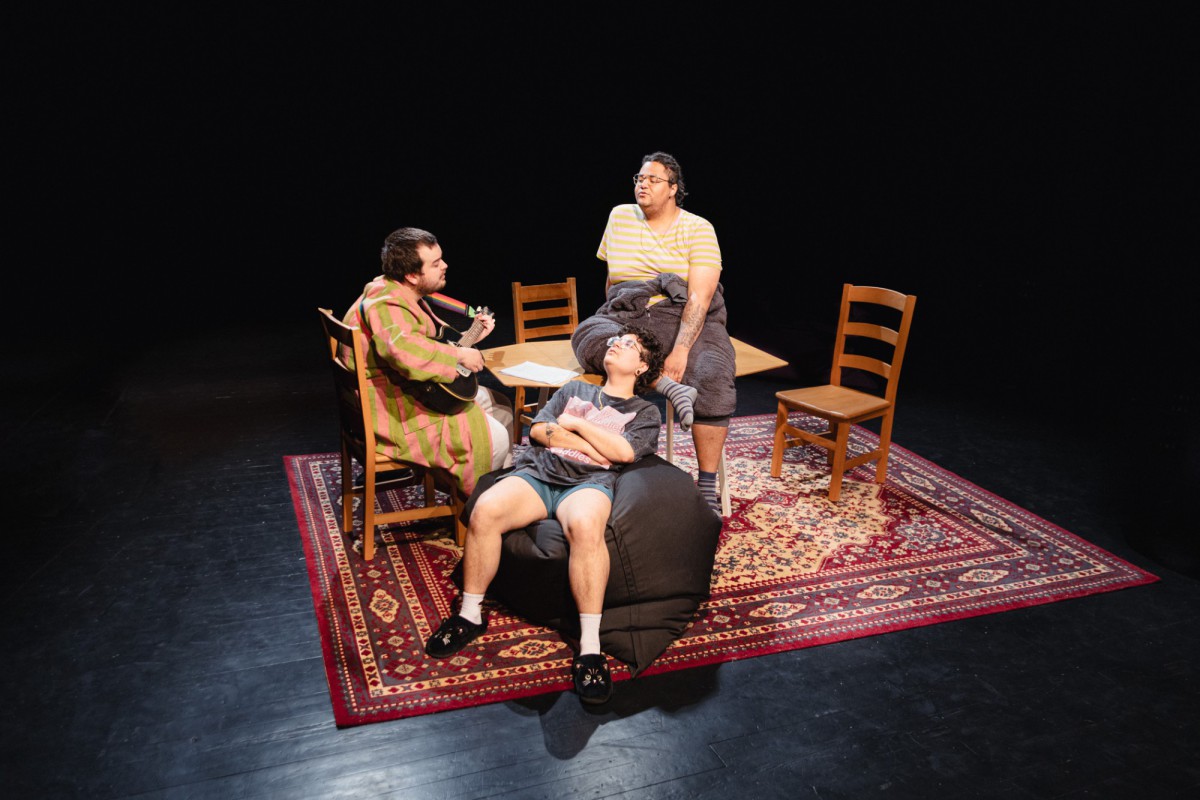 Canan Venzky, Jordan Tanner und Linus Wirth sitzen in gemütlicher Kleidung am Küchentisch