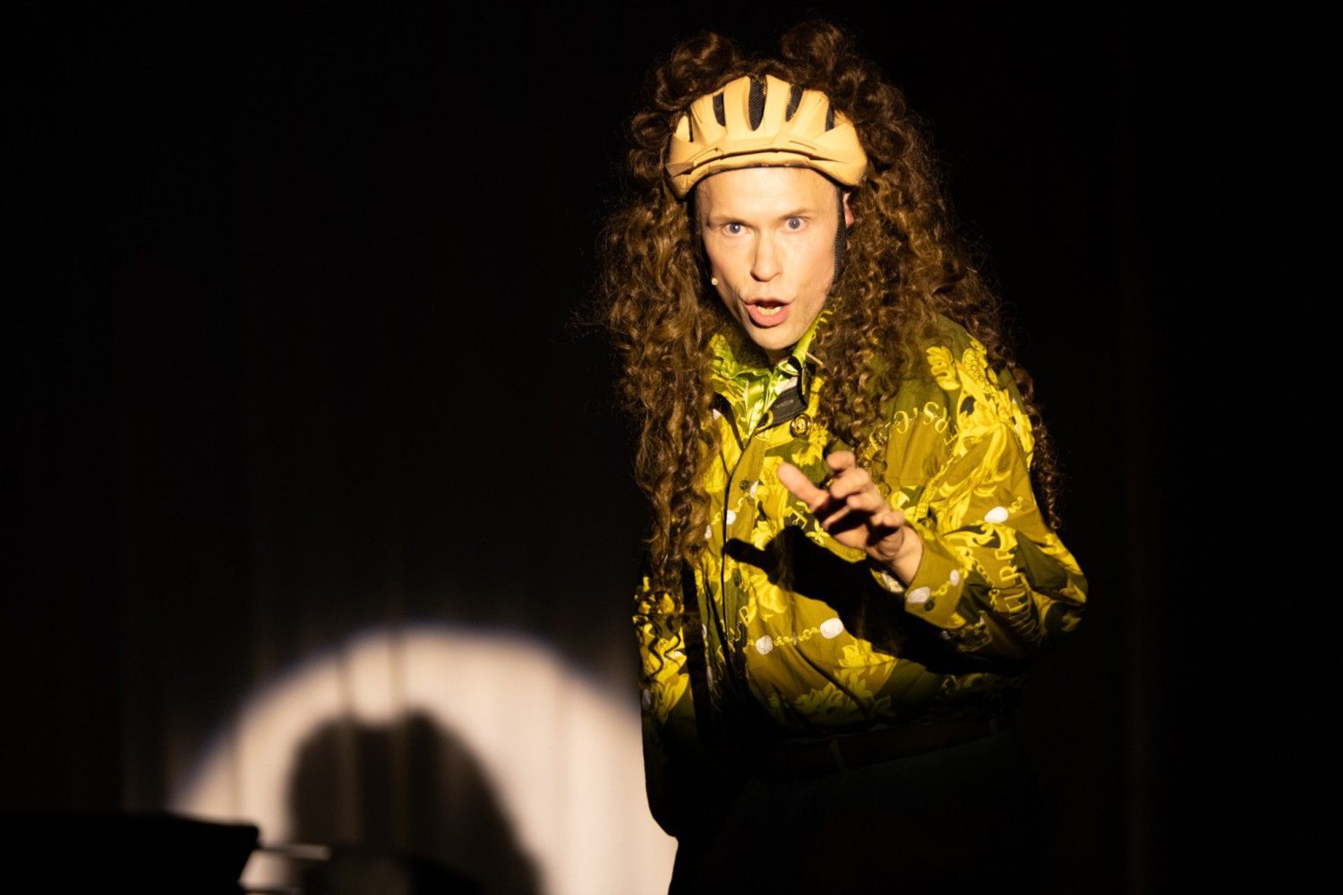 Hendrik Quast mit brauner Lockenmähne, die an einem Fahrradhelm befestigt ist