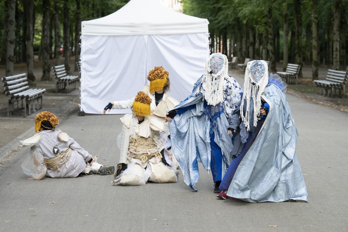 A group of performers wearing elaborate masks and costumes