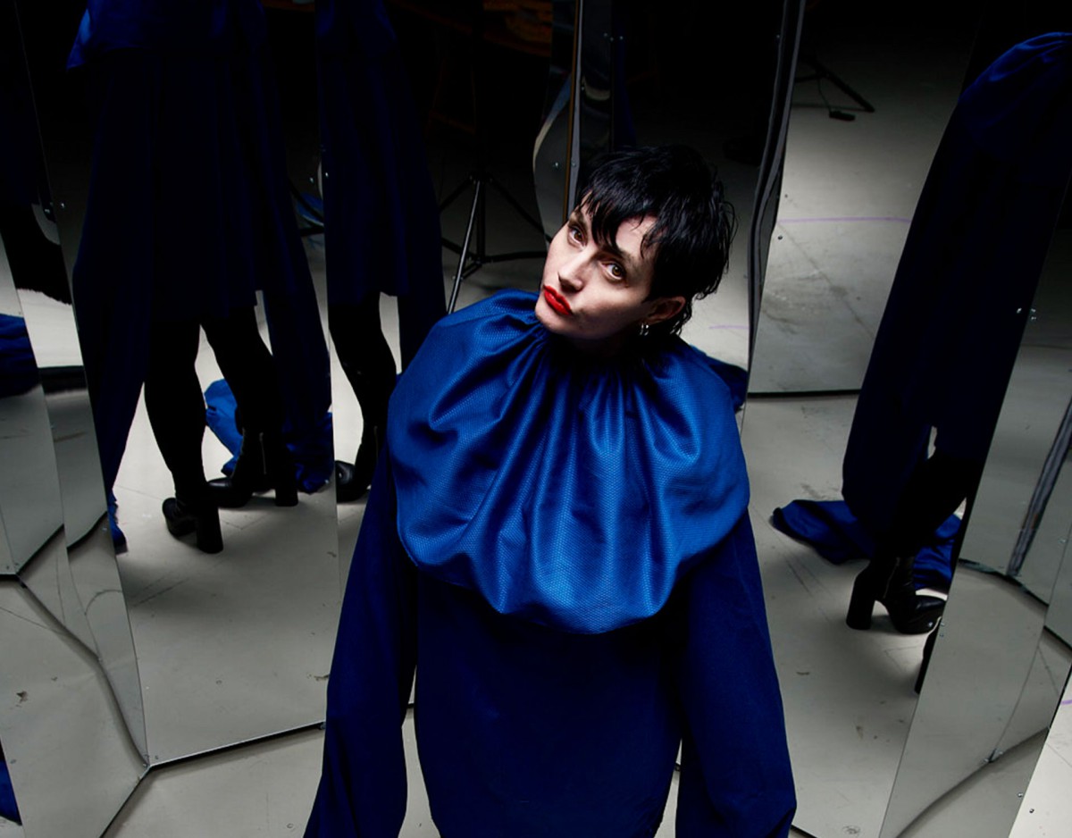 Melanie Jame Wolf, looking critically, in a hall of mirrors