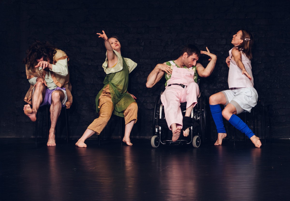 Vier Tänzer*innen mit und ohne Behinderung in gemeinsamer Pose