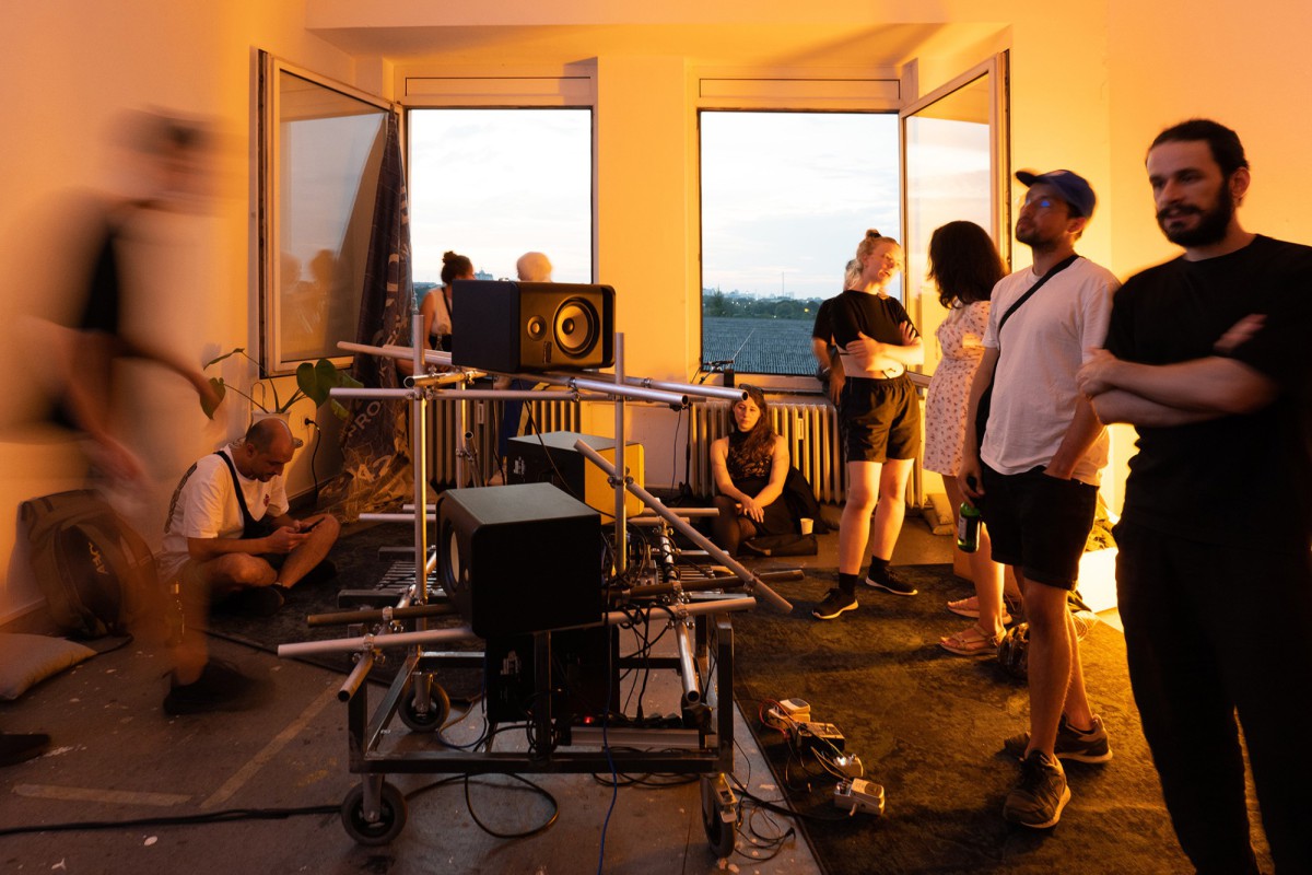 A group of people gathered around a stage listening to music